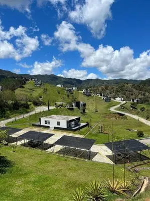 a building with a roof on a green field at Monte Hermoso - Apartamento campestre in Guatapé
