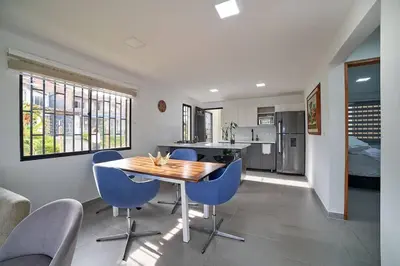 a kitchen with a wooden table and blue chairs at Monte Hermoso - Apartamento campestre in Guatapé