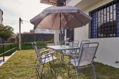 a table and chairs with a table and an umbrella at Monte Hermoso - Apartamento campestre in Guatapé