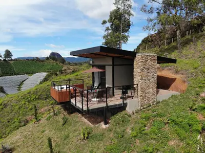a house on top of a hill with a deck at Glamping en Guatape Wifi Jacuzzi in Guatapé