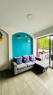 a living room with a couch and a blue wall at Baku Laureles Hostel in Medellín