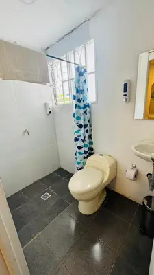 a bathroom with a toilet and a sink at Baku Laureles Hostel in Medellín