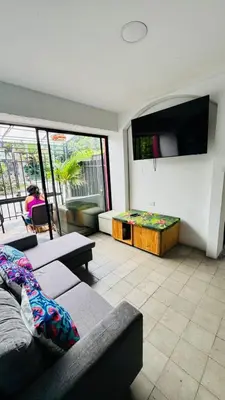 a living room with a couch and a tv at Baku Laureles Hostel in Medellín