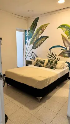 a bedroom with a bed with a mural on the wall at Baku Laureles Hostel in Medellín