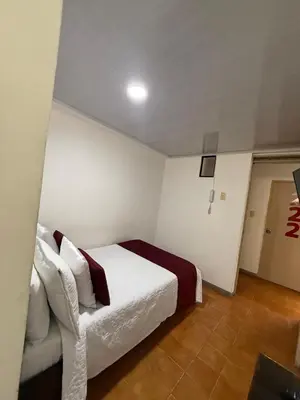 a bedroom with a white bed and a couch at Ayenda Marana in Manizales