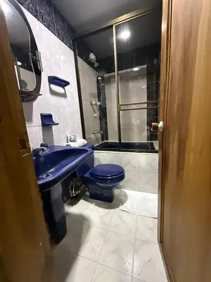 a bathroom with a blue toilet and a shower at Ayenda Marana in Manizales