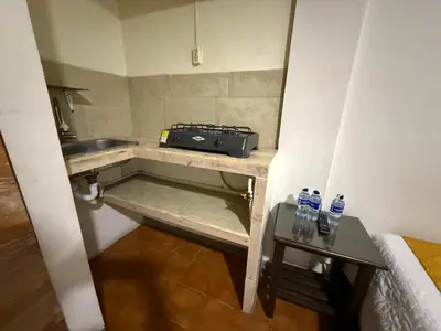 a small kitchen with a sink and two bottles of water at Ayenda Marana in Manizales
