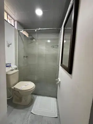 a bathroom with a toilet and a glass shower at Ayenda Marana in Manizales