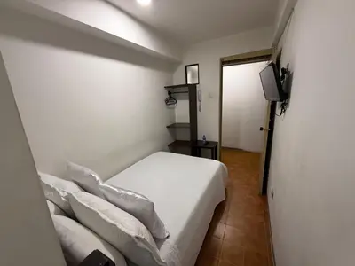 a bedroom with a bed with white sheets and pillows at Ayenda Marana in Manizales