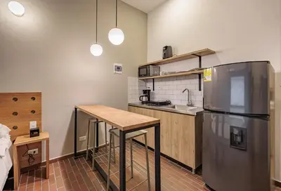 a kitchen with a table and a refrigerator at The Somos Flats Laureles in Medellín