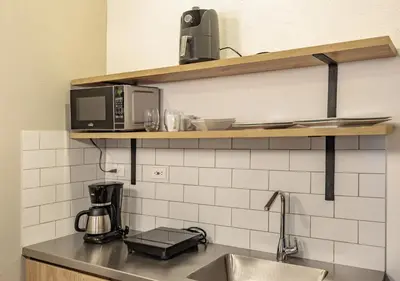 a kitchen counter with a microwave and a sink at The Somos Flats Laureles in Medellín
