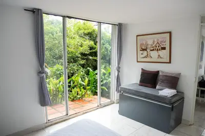 a living room with a large window and a bench at APARTAMENTO CAMPESTRE EN EJE CAFETERO in Manizales