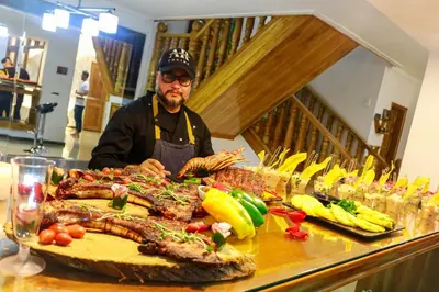 a man standing in front of a buffet of food at Económica casa con piscina privada en Medellín MLB by Lets Go in Medellín