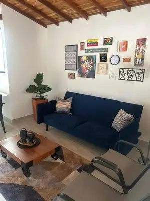 a living room with a blue couch and a table at Medellin Hermoso apartamento in Medellín