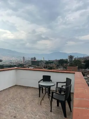 a patio with two chairs and a table on a roof at Medellin Hermoso apartamento in Medellín