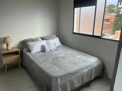a small bedroom with a bed with a window at Medellin Hermoso apartamento in Medellín