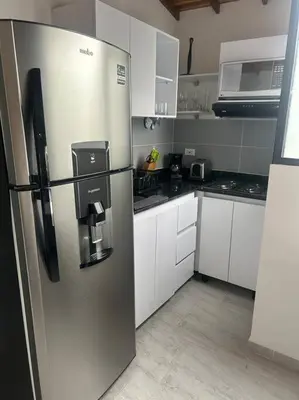 a stainless steel refrigerator in a kitchen with white cabinets at Medellin Hermoso apartamento in Medellín