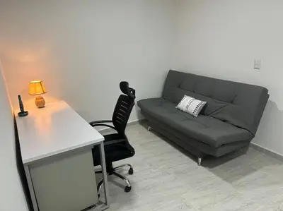 a living room with a couch and a table and a desk at Medellin Hermoso apartamento in Medellín