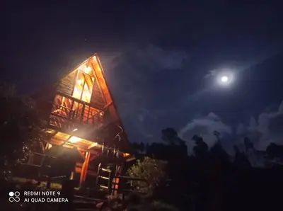 a house at night with a moon in the sky at Glamping Milagros in San Pedro