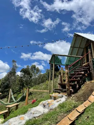 a wooden hut on a hill with a blue sky at Glamping Milagros in San Pedro