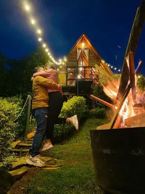 a man hugging a woman in front of a house at Glamping Milagros in San Pedro