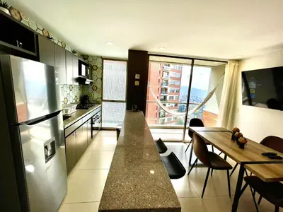 a kitchen with a refrigerator and a table with chairs at Space, best location & price! in Medellín