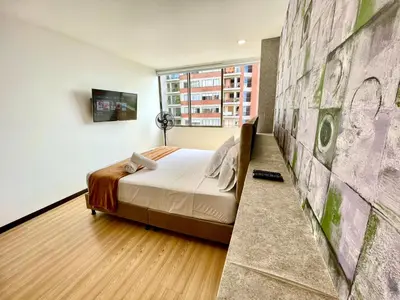 a bedroom with a bed and a painting on the wall at Space, best location & price! in Medellín