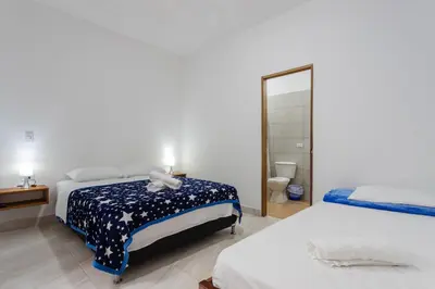 a bedroom with two beds and a mirror at Apartahotel La Gruta in Jericó