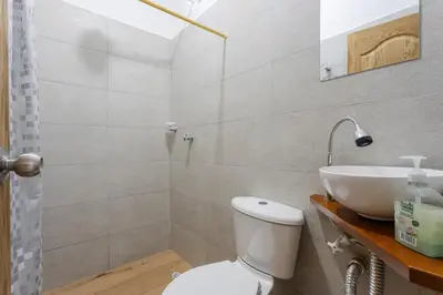 a bathroom with a white toilet and a sink at Apartahotel La Gruta in Jericó