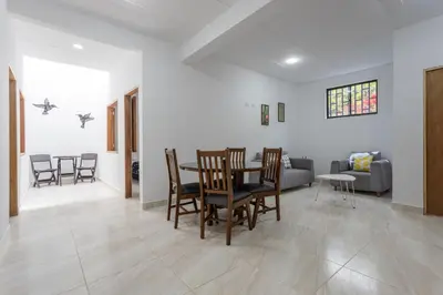 a dining room and living room with a table and chairs at Apartahotel La Gruta in Jericó