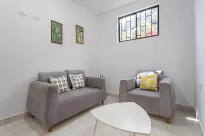 a living room with two chairs and a table at Apartahotel La Gruta in Jericó