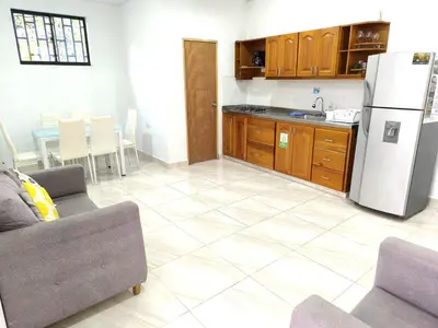 a kitchen with a refrigerator and a table with chairs at Apartahotel La Gruta in Jericó