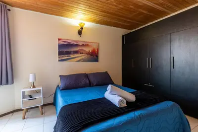 a bedroom with a blue bed and black cabinets at apartamento grande, hermoso, acogedor y privado in Medellín