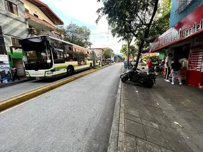 a bus driving down a city street with a scooter at apartamento grande, hermoso, acogedor y privado in Medellín