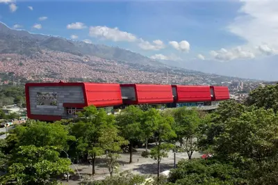 a red train is sitting on top of trees at apartamento grande, hermoso, acogedor y privado in Medellín