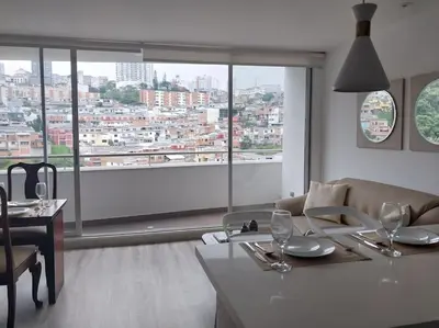 a living room with a couch and a table with wine glasses at Confortable apartamento in Manizales