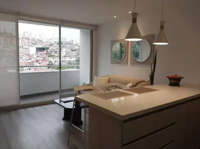 a living room with a couch and a large window at Confortable apartamento in Manizales