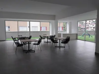 a classroom with tables and chairs and a playground at Confortable apartamento in Manizales