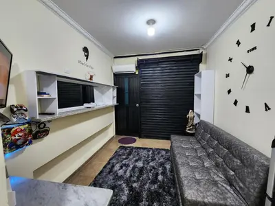 a living room with a couch and a clock on the wall at Alojamiento con Aire acondicionado - Shelter La Perla in San Luis