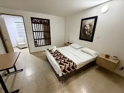 a bedroom with a bed and a table and a desk at Apartamento en laureles con excelente ubicación in Medellín