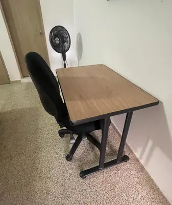 a desk with a black chair and a fan at Apartamento en laureles con excelente ubicación in Medellín