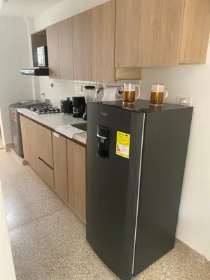 a kitchen with a black refrigerator and a stove at Apartamento en laureles con excelente ubicación in Medellín