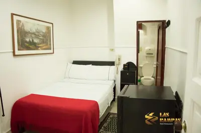 a small room with a bed and a toilet at Hotel Las Rampas in Medellín