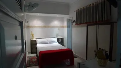 a small bedroom with a bed with a red blanket at Hotel Las Rampas in Medellín