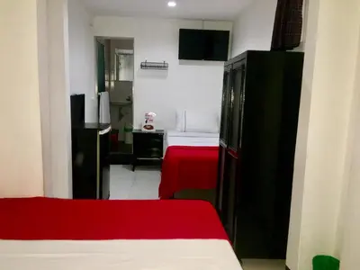a room with a bedroom with a bed and a desk at Hotel Las Rampas in Medellín
