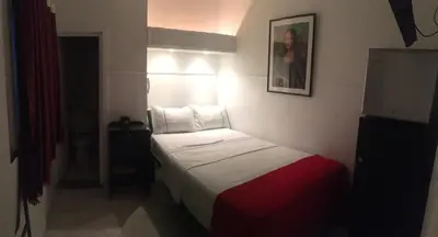 a hotel room with a bed and a picture on the wall at Hotel Las Rampas in Medellín