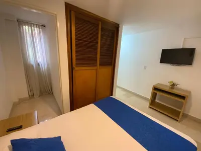 a bedroom with a bed and a television in it at Amoblados Medellín Laureles in Medellín