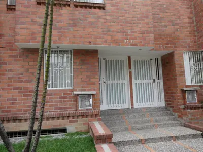 a red brick building with white doors and stairs at Amoblados Medellín Laureles in Medellín