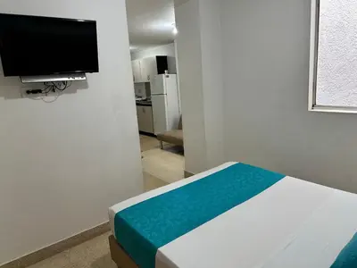 a room with a bed and a tv on a wall at Amoblados Medellín Laureles in Medellín