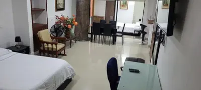 a bedroom with a bed and a dining room with chairs at Pilarica Gardens in Medellín